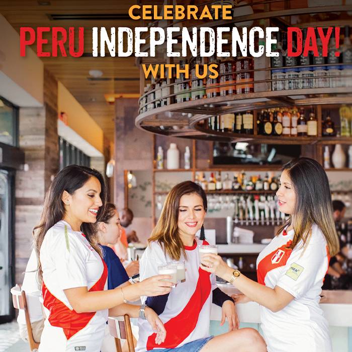 Group of women wearing Peru soccer jerseys celebrating with pisco sours at a bar, toasting and enjoying the moment.
